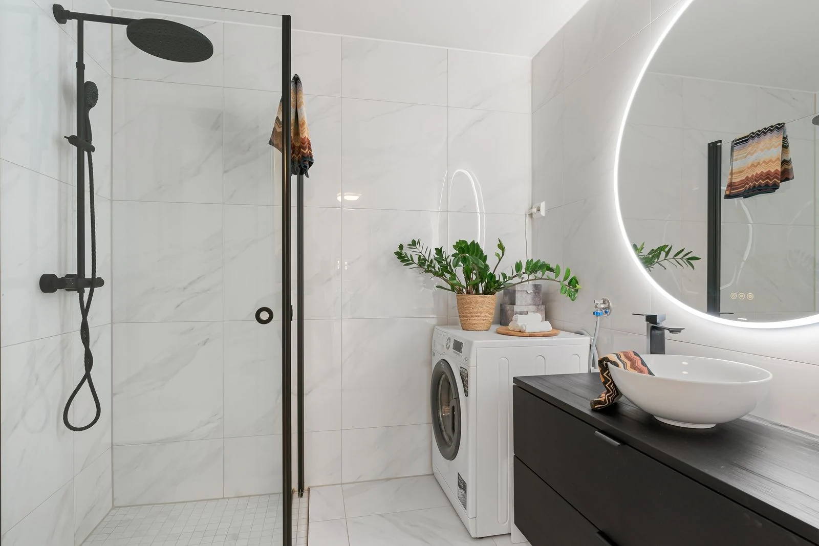 Elegant bathroom interior featuring a minimalist design with shower and laundry area