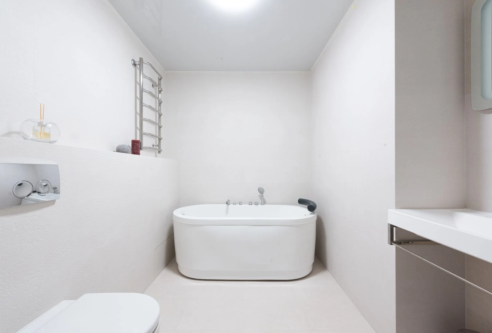 Modern bright bathroom interior with white toilet and sink near bath and decorative elements
