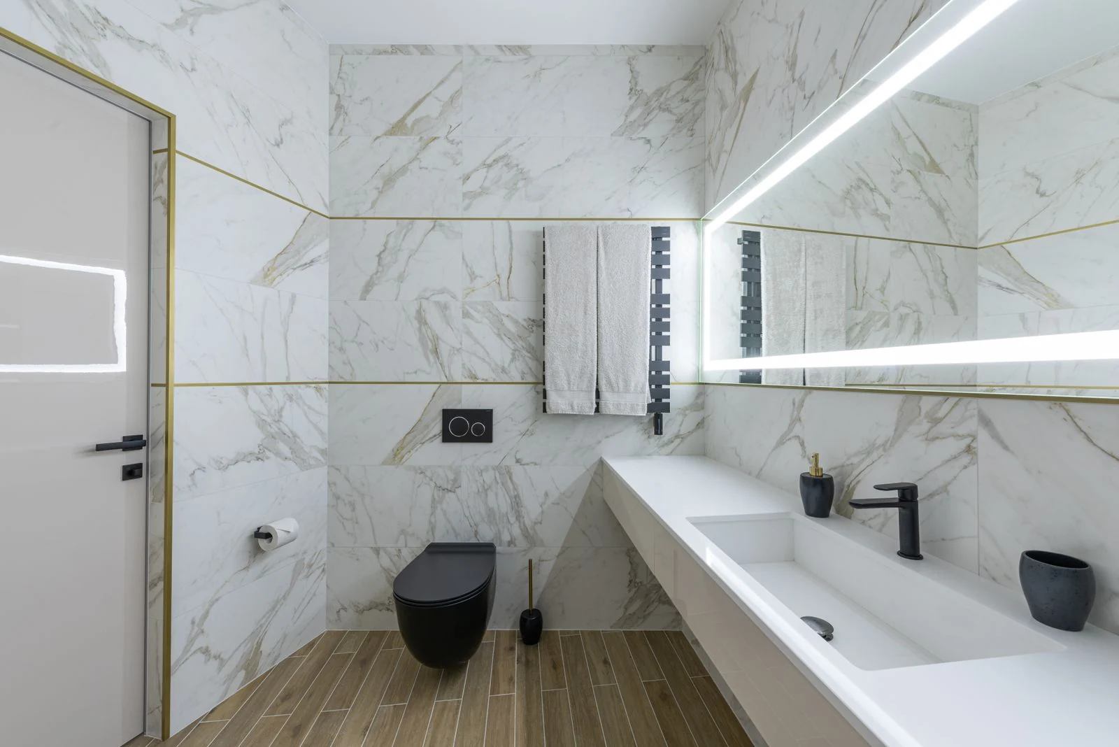 Interior of contemporary bathroom with marble walls and ceramic sink in modern minimalist apartment