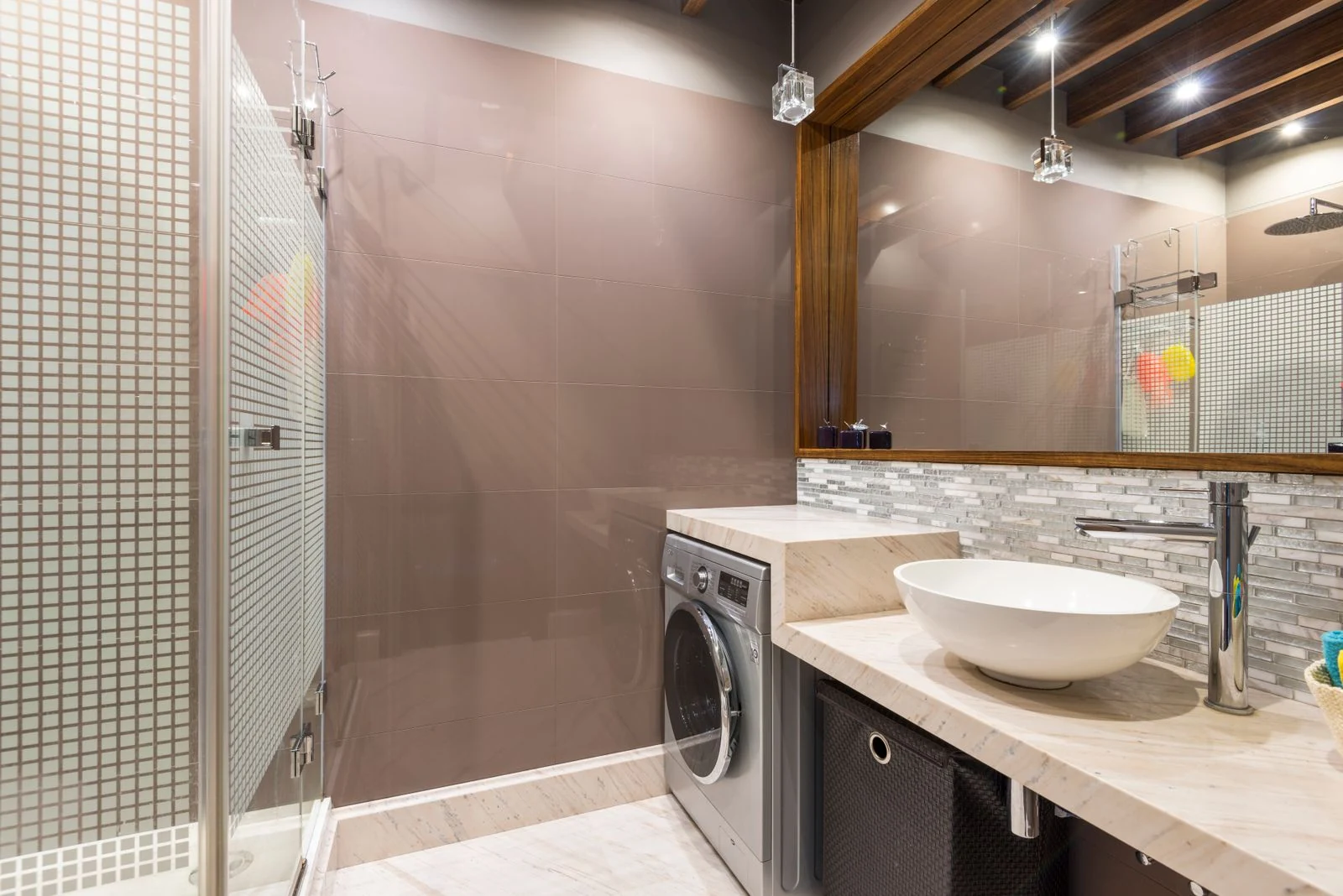 A contemporary bathroom featuring a washer, vessel sink, and stylish decor